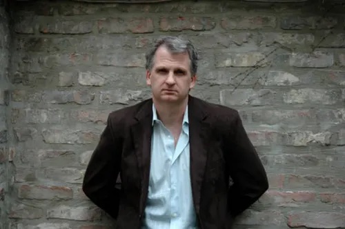 Photo of Timothy Snyder standing against a brick wall. 