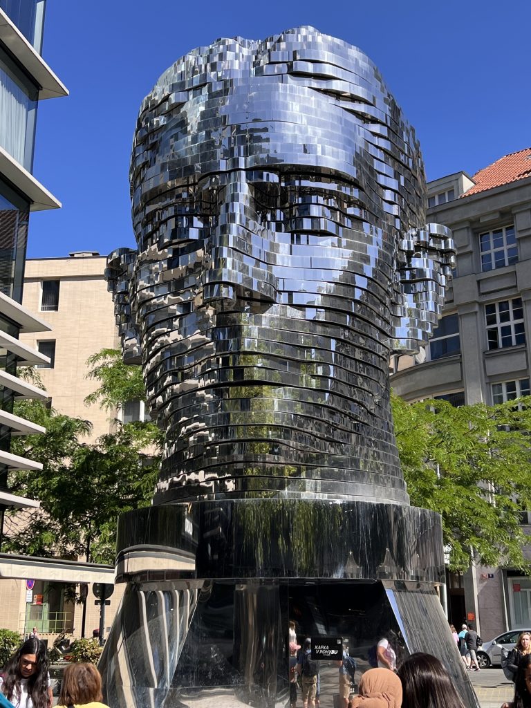 Statue of Franz Kafka by David Černý (2014), composed of 42 stainless steel layers that rotate independently, finally periodically. aligning to form the face of Kafka.